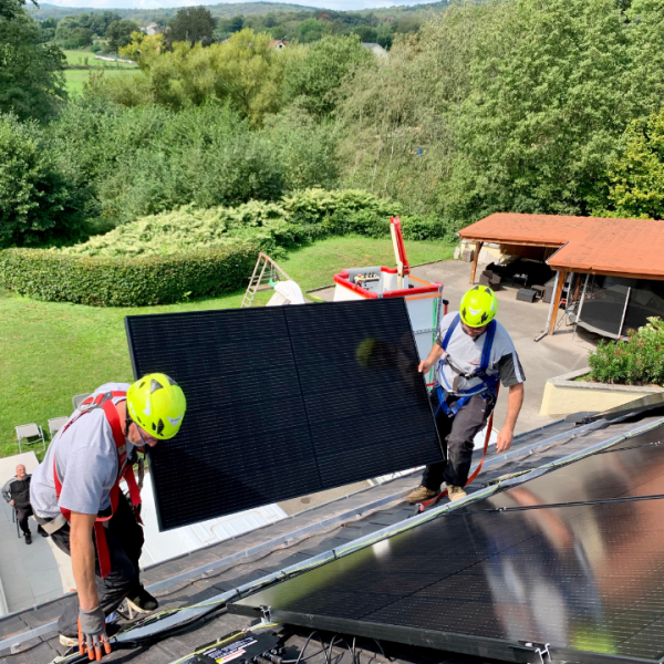 Installateurs de panneaux solaires sur toiture de maison.